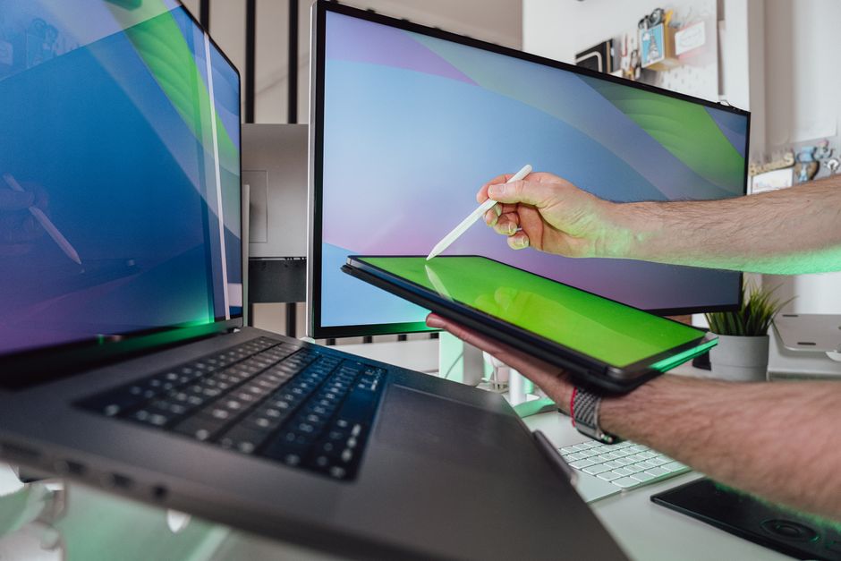 Osoba koja koristi tablet u tech okruženju s dual monitorima