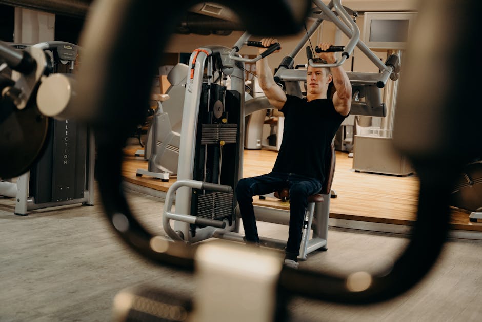 A man working out on a gym machine, focusing on upper body strength training.