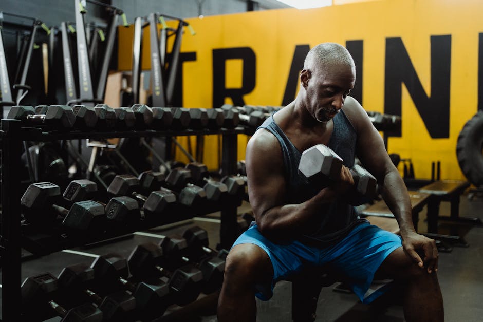 Adult man performing dumbbell curls in a modern gym, emphasizing strength and fitness