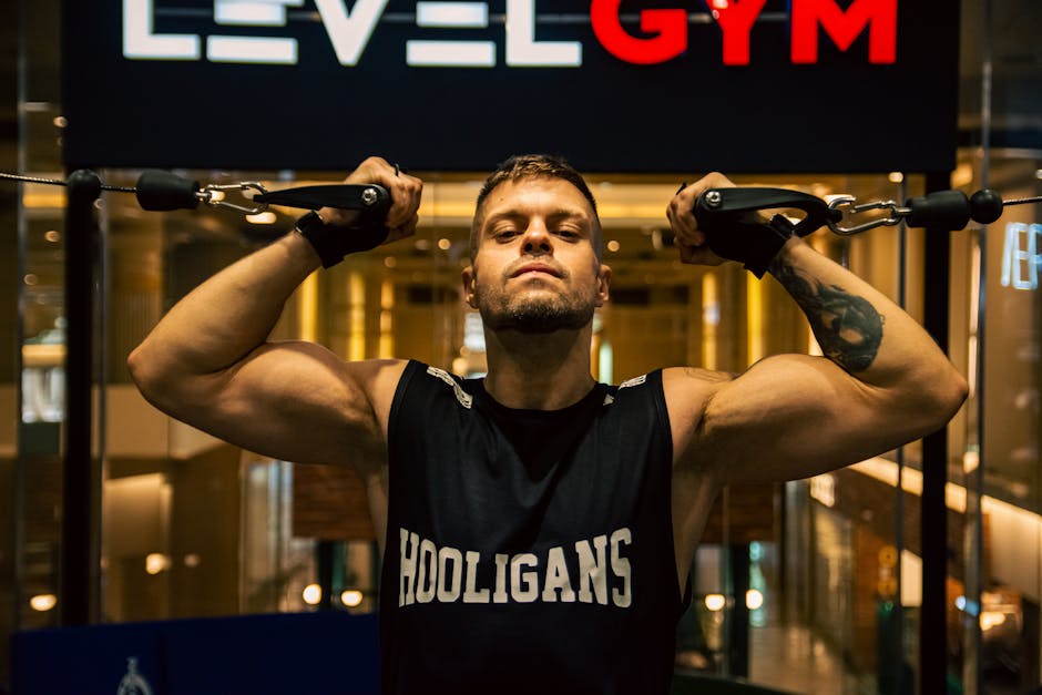 A muscular man working out at a modern indoor gym, demonstrating strength training